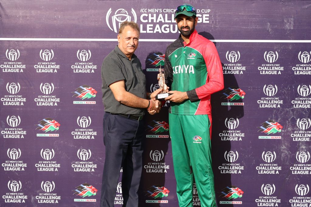 Irfan Karim receives Player of the match award after scoring a century against Denmark in the ICC CWC Challenge League A